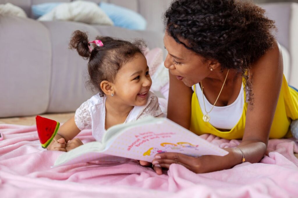 A mother and daughter reading a book together.